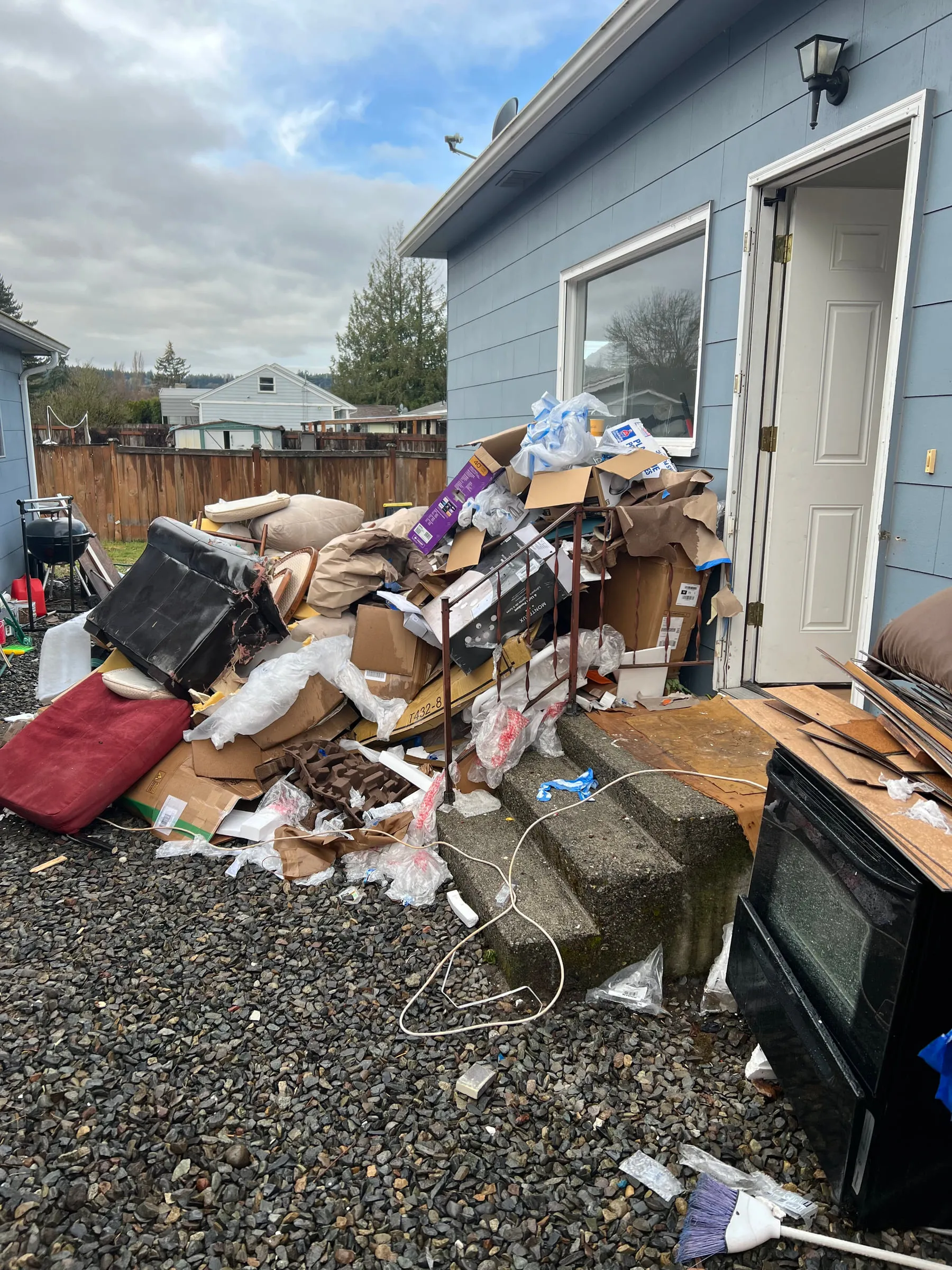 A large pile of household junk cleared onto a driveway ready for loading
