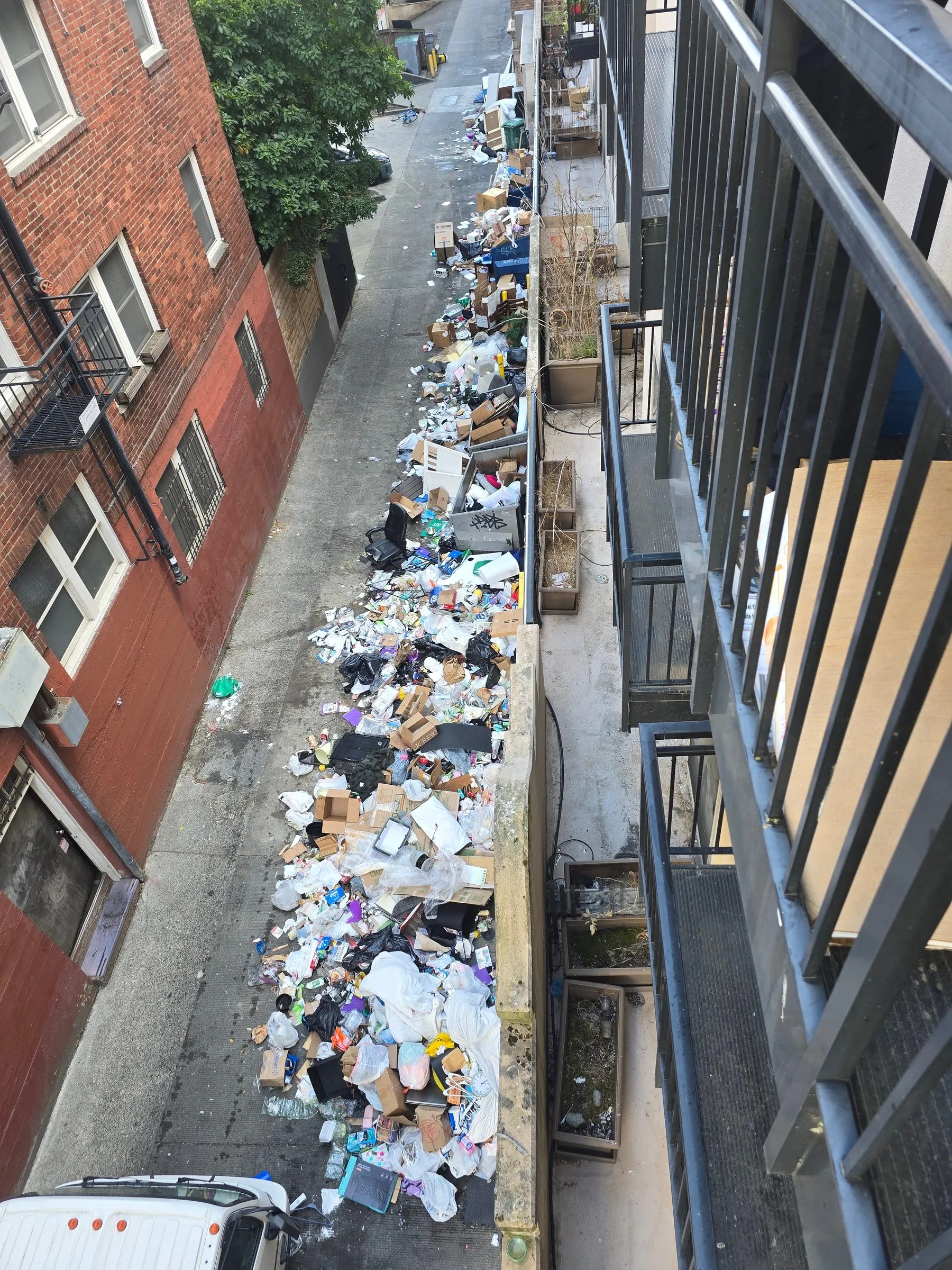 Looking down a downtown Seattle alley buried end to end in bags, boxes and discarded furniture