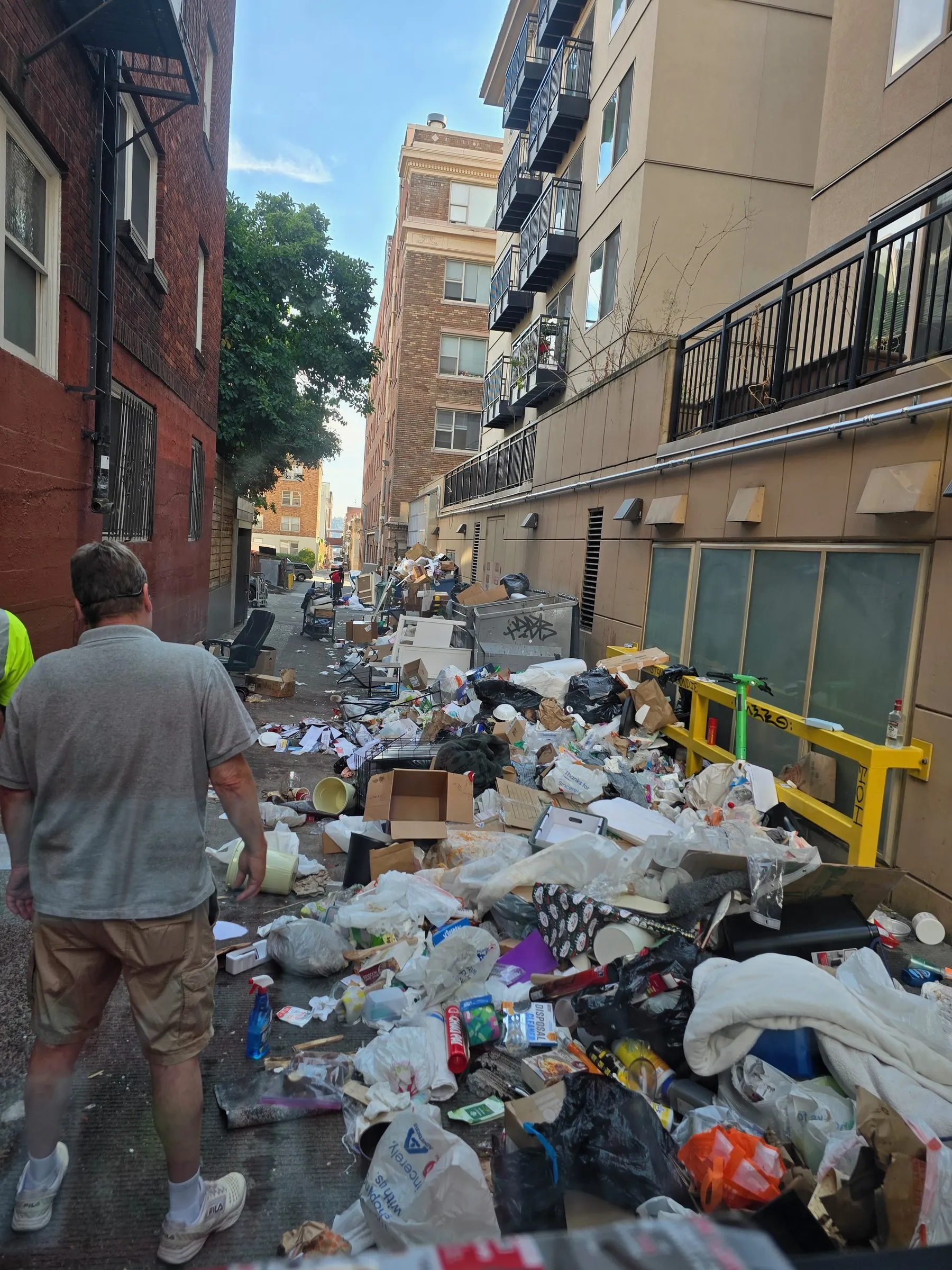 Ground level in the alley before the clear-out, debris covering the full width of the pavement